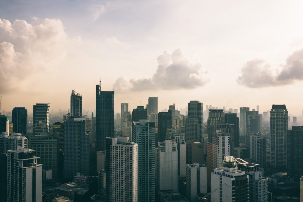 a picture of a city skyline during the day with beautiful clouds.