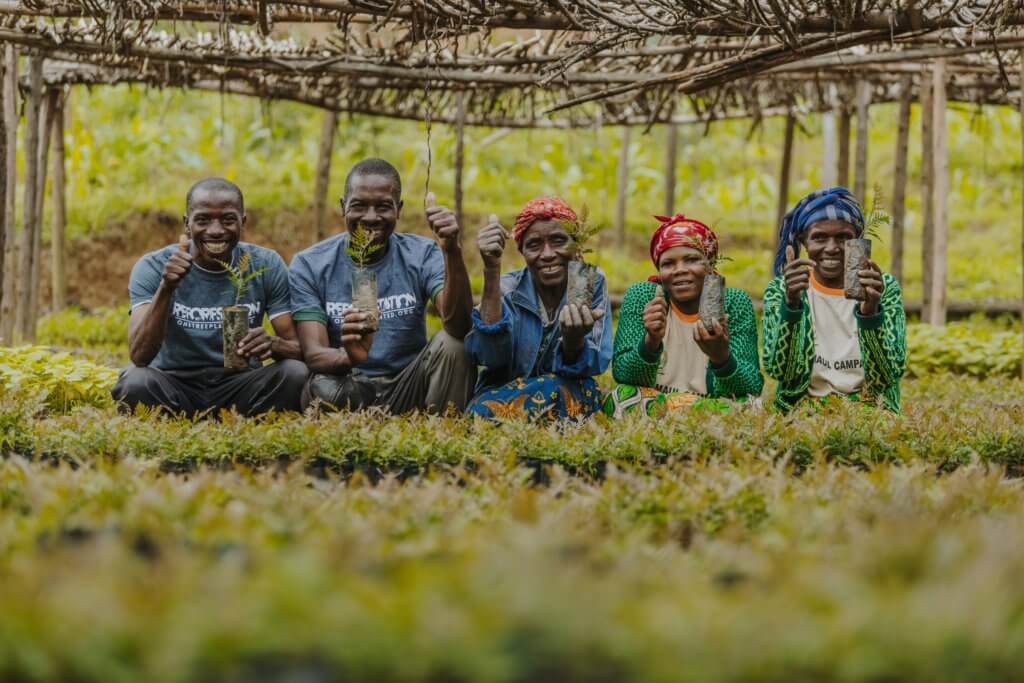 Two men and three women carrying plantlings in a One Tree Planted Restoration Project in East Africa 